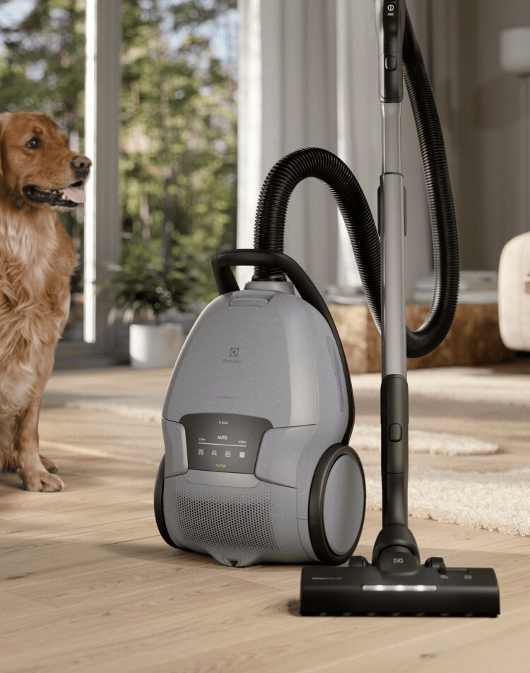 Vysávač Electrolux v obývacej izbe spoločne so ženou a psom.