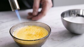 Pekár karamelizujúci cukor na creme brulee flambovacou pištoľou