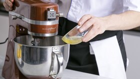 Šéfkuchár spoločnosti Electrolux pomaly pridávajúci ingrediencie do koláča