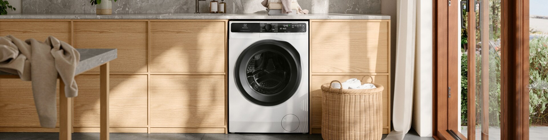 Práčka Electrolux stojí vo svetlej práčovni. 