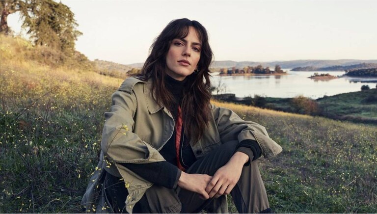 Žena sediaca na tráve v prírode.