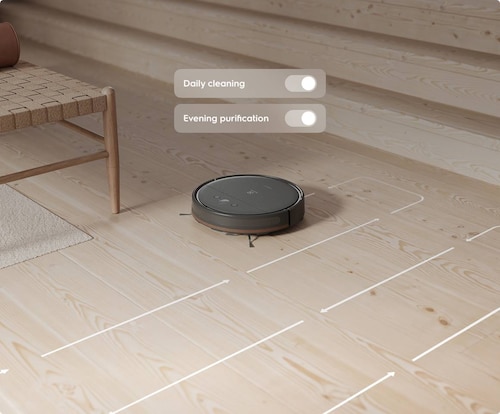 Robotický vysávač na podlahe.