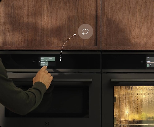 Muž si ukladá obľúbené nastavenia na vestavných rúrach.